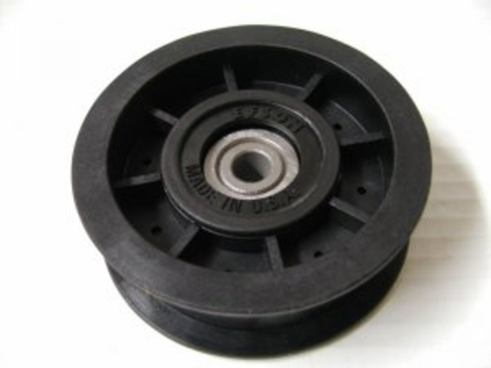 Black pulley wheel with metal bearing on a white background